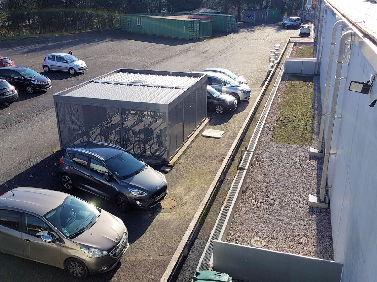 Photo : récupération des eaux pluviales, façade Est du bâtiment et local vélos