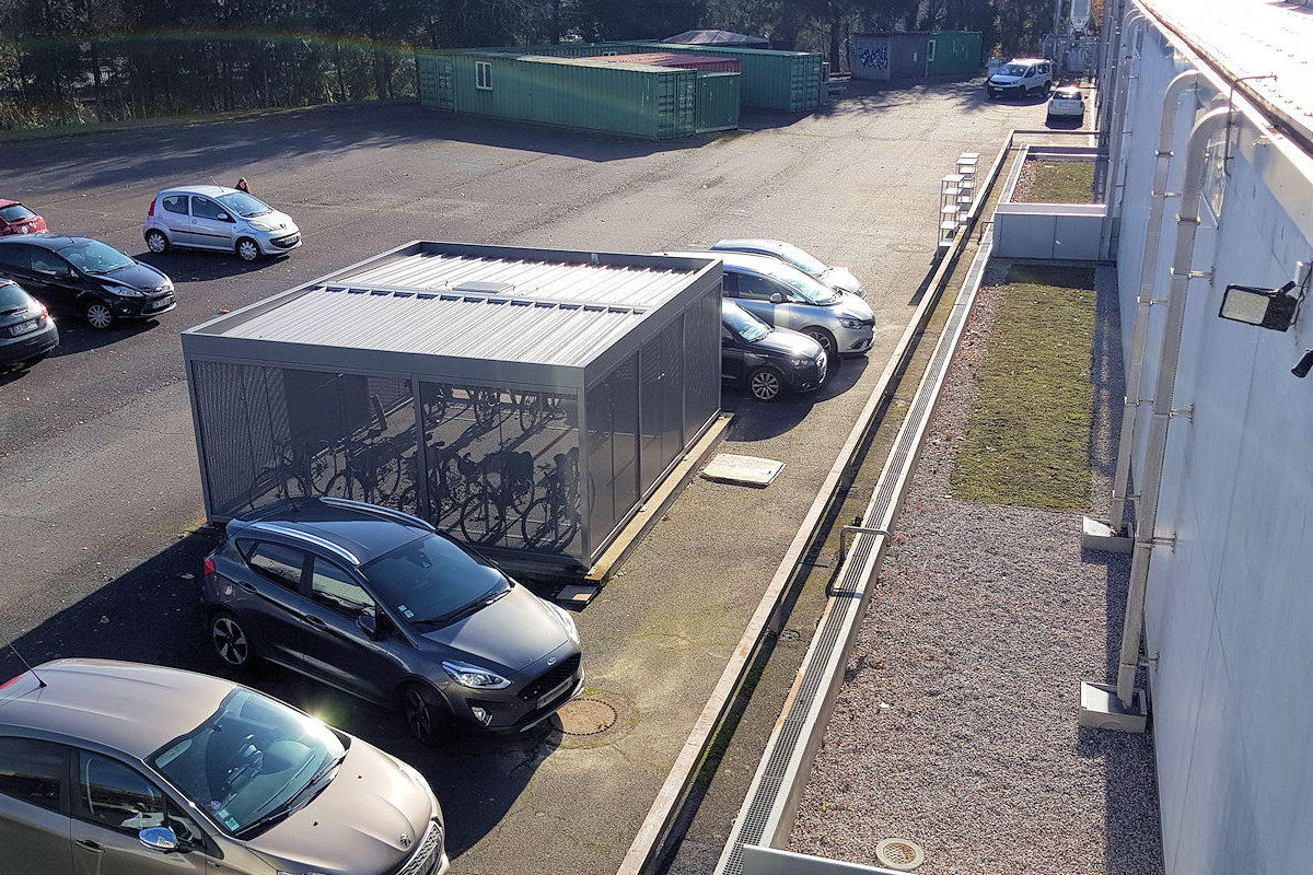 Photo : Récupération de l'eau de pluie, façade Est du bâtiment et local à vélos